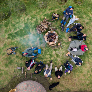 Aerial view of a group of people surrounding the fire pit at the campsite An aerial view of a group of people surrounding the fire pit at the campsite